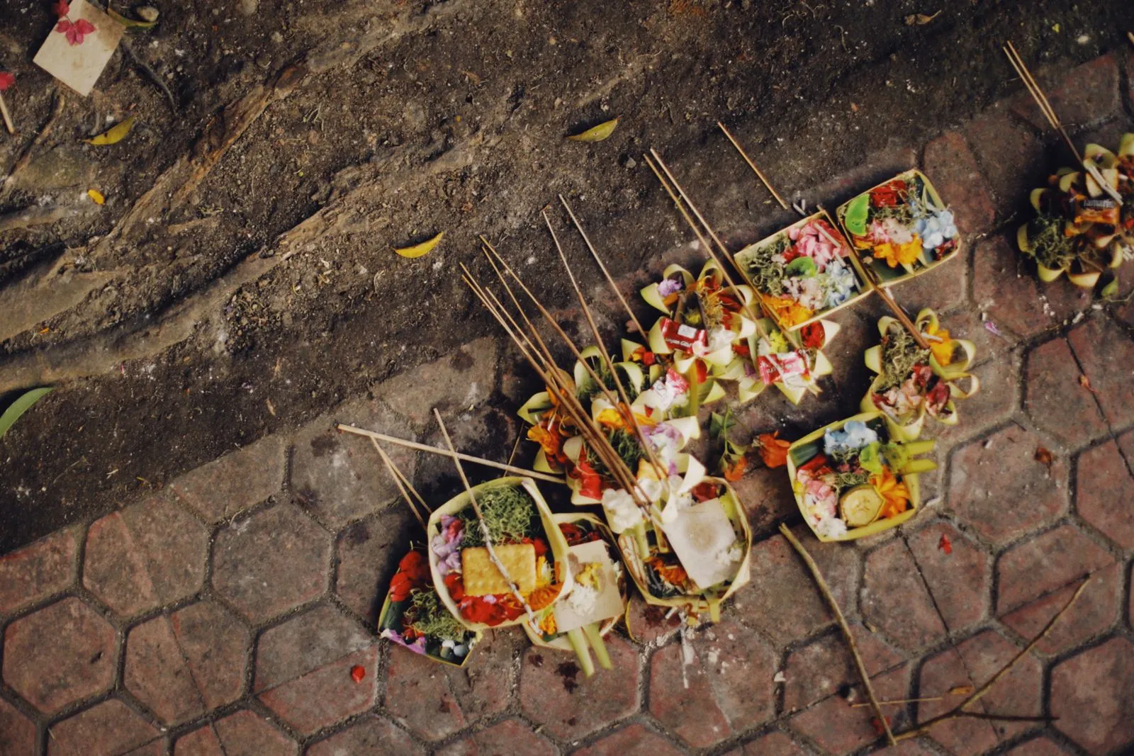 Canang sari offerings left on the paving of a street